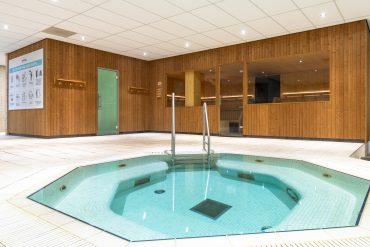 Onze wellness is een mooie aanvulling op jouw sportervaring. Wij bieden hierbij de volgende faciliteiten: sauna, stoomcabine, whirlpool en een separaat zwembad. Het zwembad wordt daarbij ook gebruikt voor zwemlessen, aquafit en BPK zwemmen. Tijdens deze lessen is het zwembad niet toegankelijk voor wellness gasten.  Het woord wellness is een combinatie van de Engelse woorden “well being'” en “fitness”. Na het sporten helpt wellness jouw lichaam ontspannen terwijl het tegelijkertijd hard aan het werk is. Door de heftige temperatuurswisselingen van de sauna en het stoombad richten jouw hersenen alle energie op de vitale levensfuncties en komt jouw geest hierdoor even helemaal los van de alledaagse beslommeringen.  Als je gekozen hebt voor onze wellness add-on ben je hier 7 dagen per week welkom. De wellness is op een aantal dagen per jaar gesloten in verband met besloten activiteiten. Check hier onze openingstijden. In de wellness is het gebruik van officiële zwemkleding, slippers en een handdoek verplicht en is het gebruik van telefoons en tablets verboden.